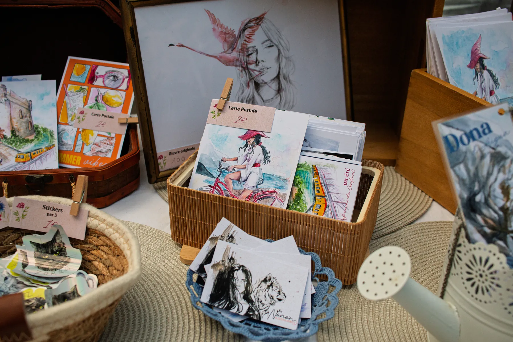 Papeterie illustrée et cartes postales présentées sur un marché dans les Pyrénées-Orientales